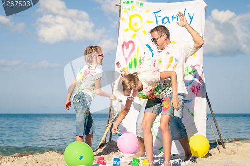 Image of Father and children playing on the beach at the day time.