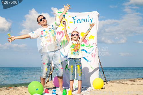 Image of Father and daughter playing on the beach at the day time.