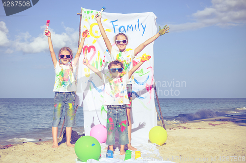 Image of Two sisters and brother playing on the beach at the day time.