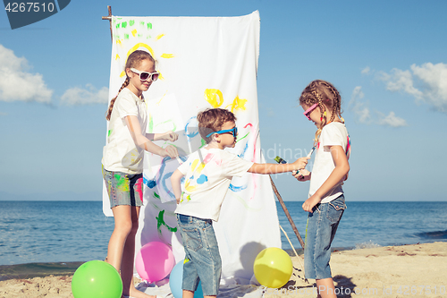 Image of Two sisters and brother playing on the beach at the day time.