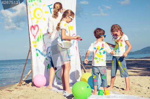 Image of Mother and children playing on the beach at the day time.