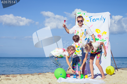 Image of Father and children playing on the beach at the day time.