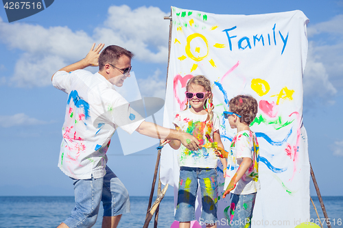 Image of Father and children playing on the beach at the day time.