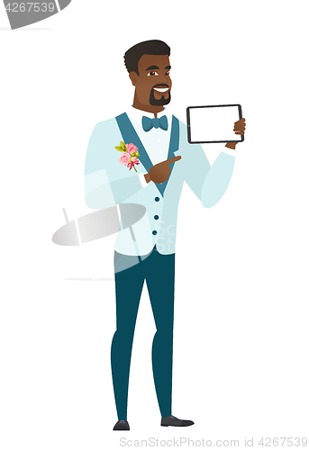 Image of Smiling groom holding tablet computer.