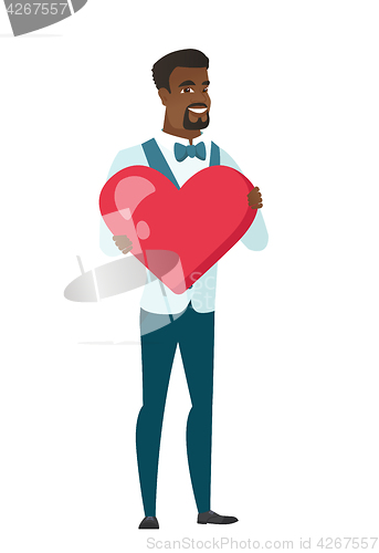 Image of African-american groom holding a big red heart.