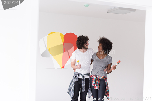 Image of couple with painted heart on wall
