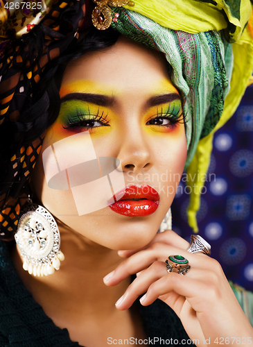 Image of beauty bright woman with creative make up, many shawls on head l