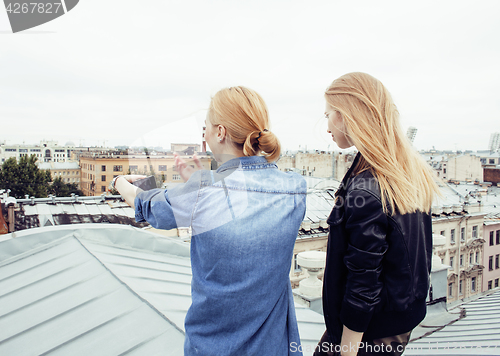 Image of two cool blond real girls friends making selfie on roof top, lifestyle people concept, modern teens
