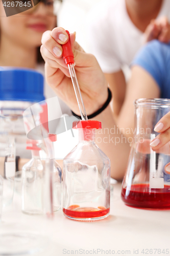 Image of Schoolgirl performs chemical experience.