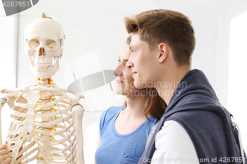 Image of Schoolgirl watching model of a human skeleton.