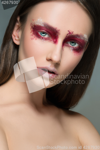 Image of Beautiful woman face portrait close up with red make up