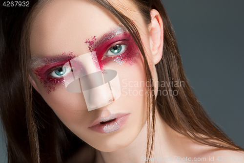 Image of Beautiful woman face portrait close up with red make up