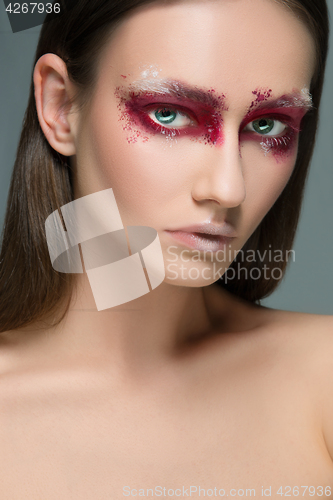 Image of Beautiful woman face portrait close up with red make up