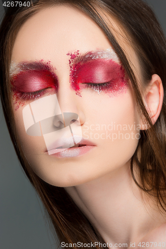 Image of Beautiful woman face portrait close up with red make up