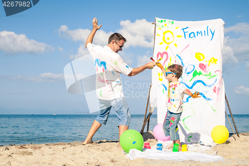 Image of Father and son playing on the beach at the day time.