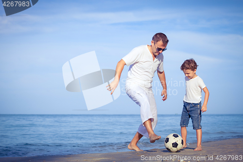 Image of Father and son playing on the beach at the day time.