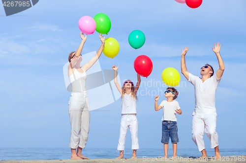 Image of Happy family jumping on the beach at the sunset time.