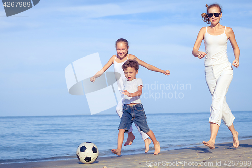 Image of Mother and children playing on the beach at the day time.