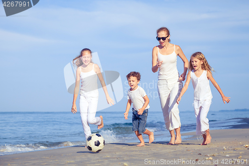 Image of Mother and children playing on the beach at the day time.