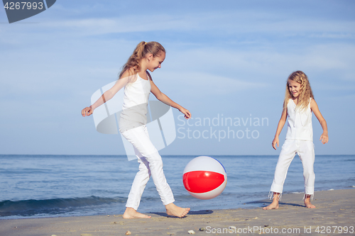 Image of Two sisters playing on the beach at the day time.