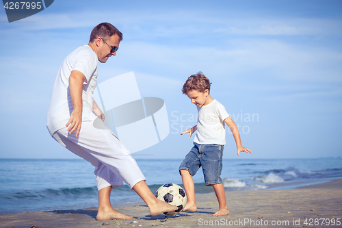 Image of Father and son playing on the beach at the day time.