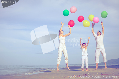 Image of Happy family playing on the beach at the day time.