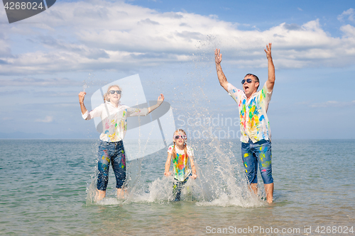 Image of Happy family playing on the beach at the day time.