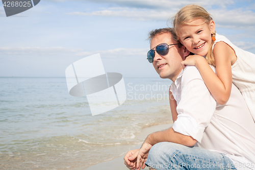 Image of Father and daughter playing on the beach at the day time.