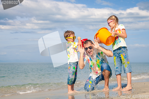 Image of Father and children playing on the beach at the day time.