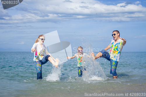 Image of Happy family playing on the beach at the day time.