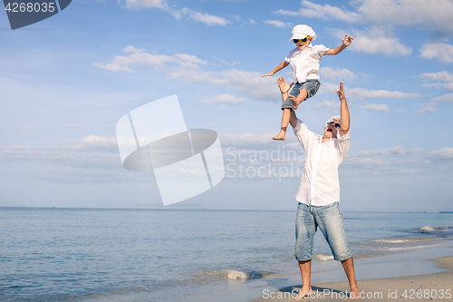 Image of Father and son playing on the beach at the day time.