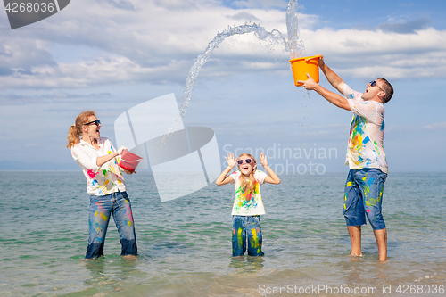 Image of Happy family playing on the beach at the day time.