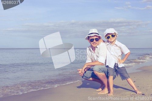 Image of Father and son playing on the beach at the day time.