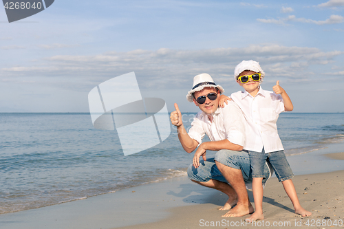 Image of Father and son playing on the beach at the day time.