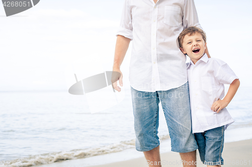 Image of Father and son playing on the beach at the day time.