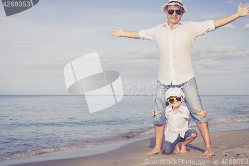 Image of Father and son playing on the beach at the day time.