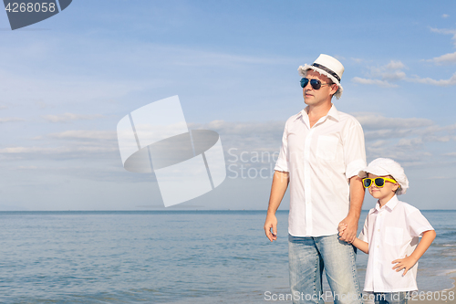 Image of Father and son playing on the beach at the day time.