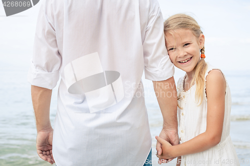 Image of Father and daughter playing on the beach at the day time.