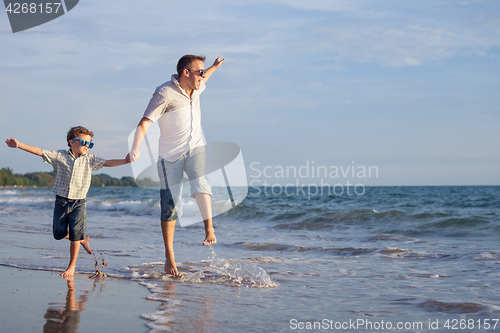 Image of Father and son playing on the beach at the day time.