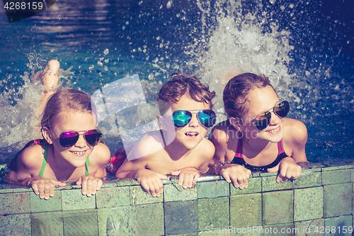 Image of happy children  playing on the swimming pool at the day time