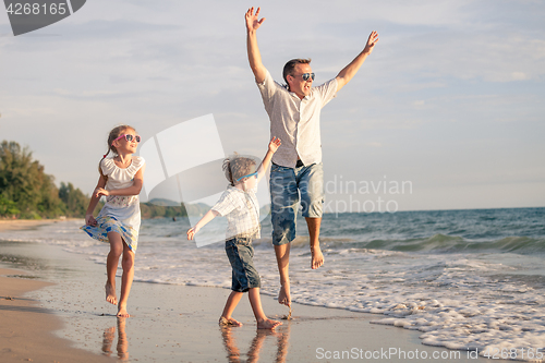 Image of father and children playing on the coast of lake