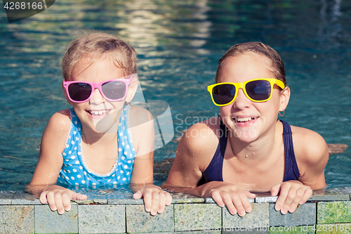 Image of Two happy children  playing on the swimming pool at the day time