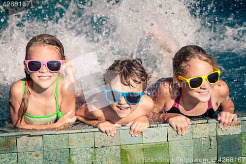 Image of happy children  playing on the swimming pool at the day time