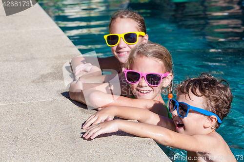 Image of happy children  playing on the swimming pool at the day time