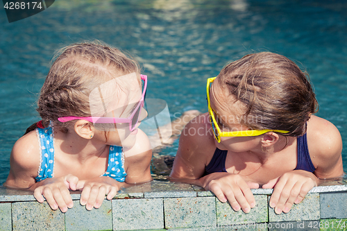 Image of Two happy children  playing on the swimming pool at the day time