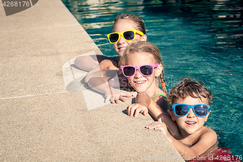 Image of happy children  playing on the swimming pool at the day time