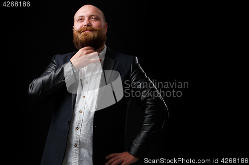 Image of Young man strokes ginger beard