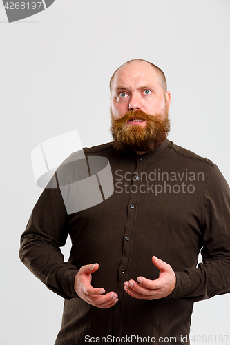 Image of Surprised man with brown shirt