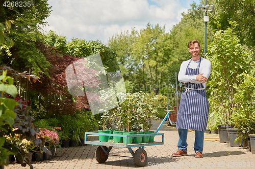 Image of Cheerful gardener with wagon