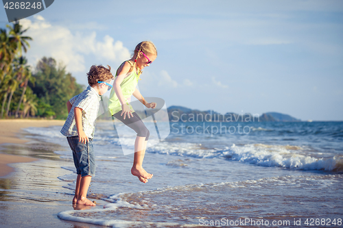 Image of Happy children playing on the beach at the day time.